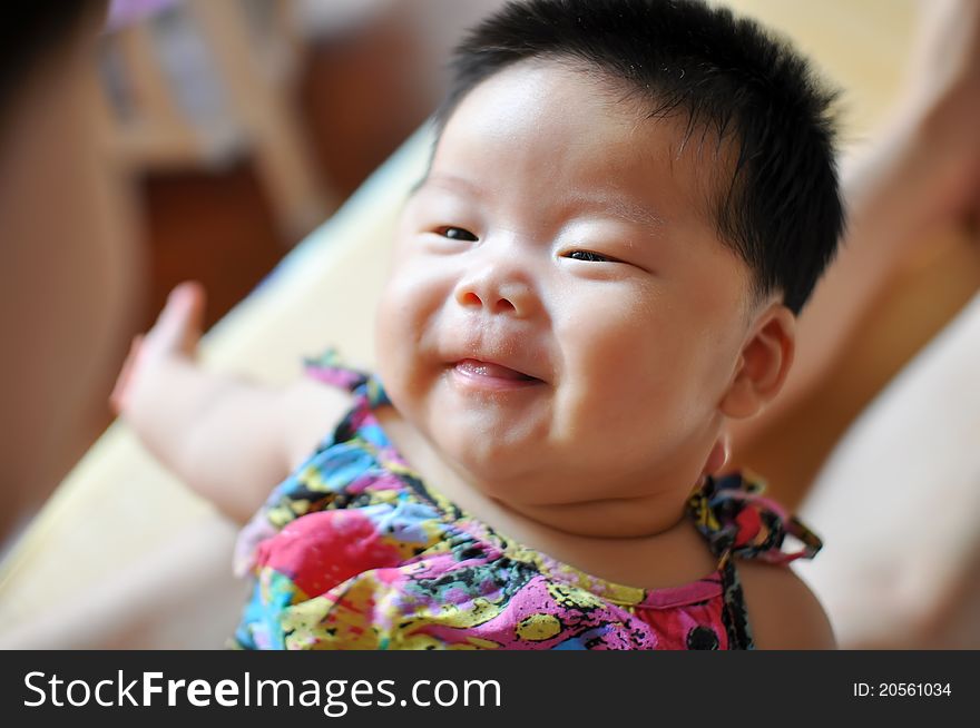 A 2 months chinese Baby girl smiling to her mother. A 2 months chinese Baby girl smiling to her mother