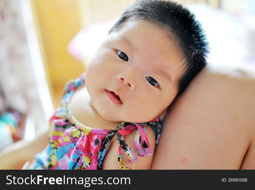 A 2 months chinese Baby girl lying on her mom's legs