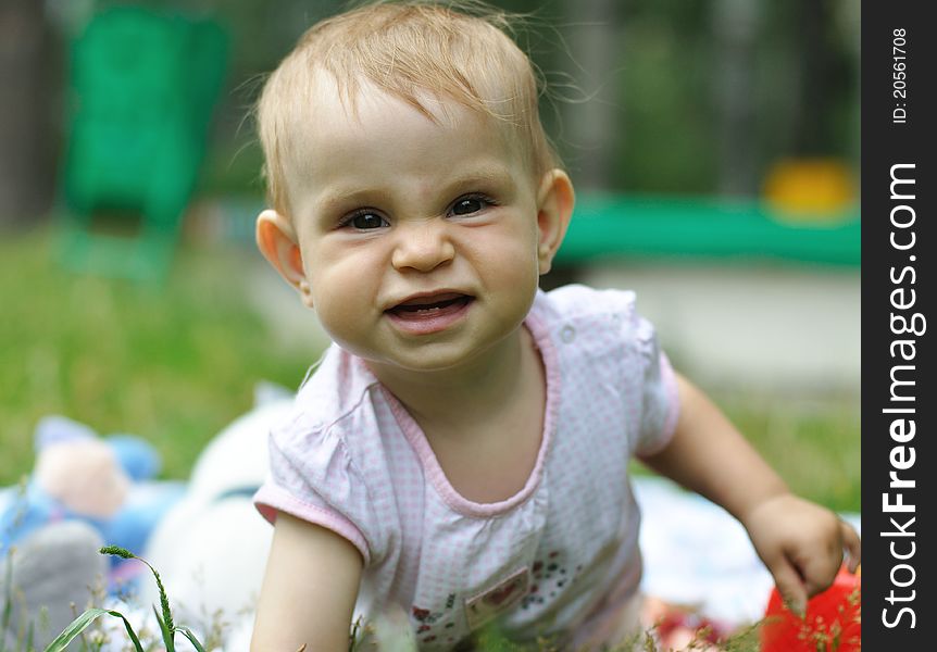 Little baby girl playing on the lawn. Little baby girl playing on the lawn