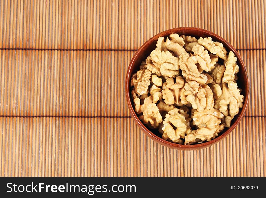 Walnut in a bowl on the background of a bamboo mat
