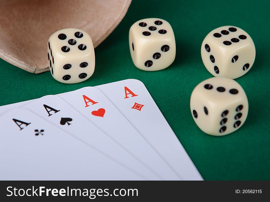 Closeup of four aces and four dices on green background. Closeup of four aces and four dices on green background