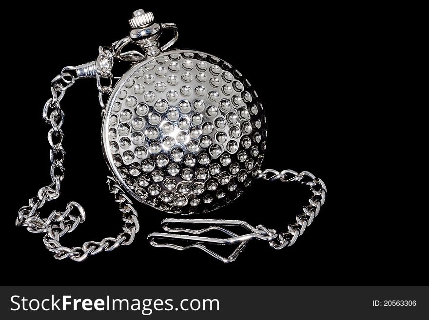 Closed old pocket watch with chain at black background