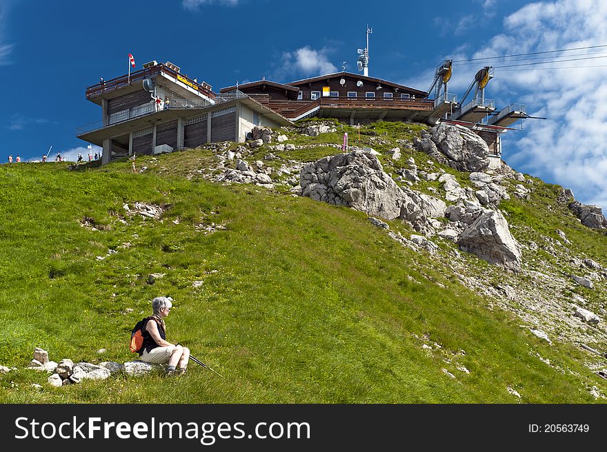 Woman sitting at the summit station of the Nebelhorn cable car. Woman sitting at the summit station of the Nebelhorn cable car