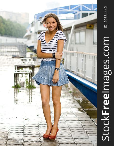 Girl walking outdoor on embankment under rain