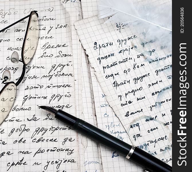 Fountain pen and eyeglasses over ancient writings.close up photo