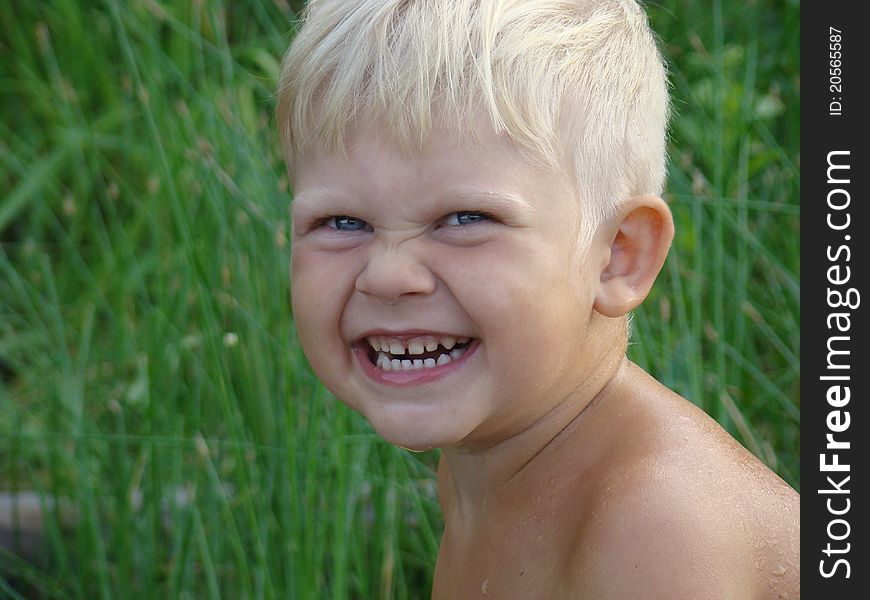 Smiling boy on green grass background. Smiling boy on green grass background