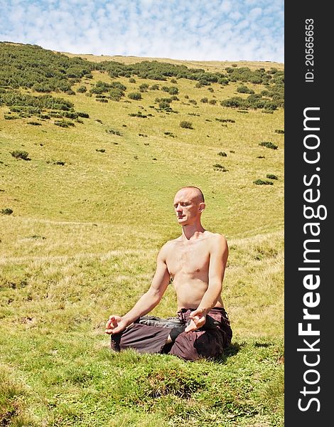 Man meditating at the foot of the mountain