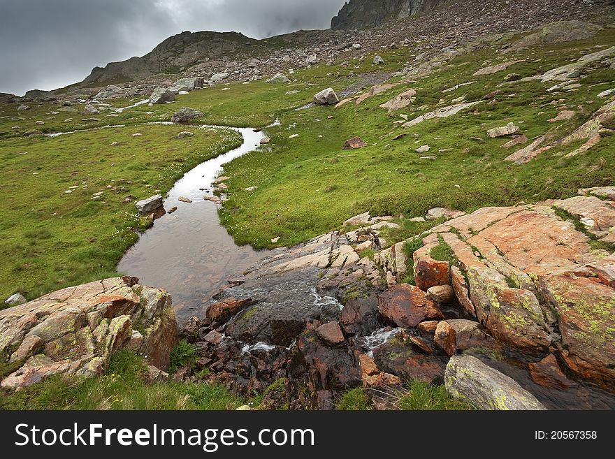 Mountain torrent in high mountain during summer with a foggy sky. Mountain torrent in high mountain during summer with a foggy sky