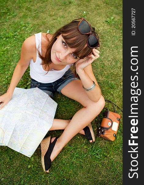 Portrait of happy young tourist girl with the map