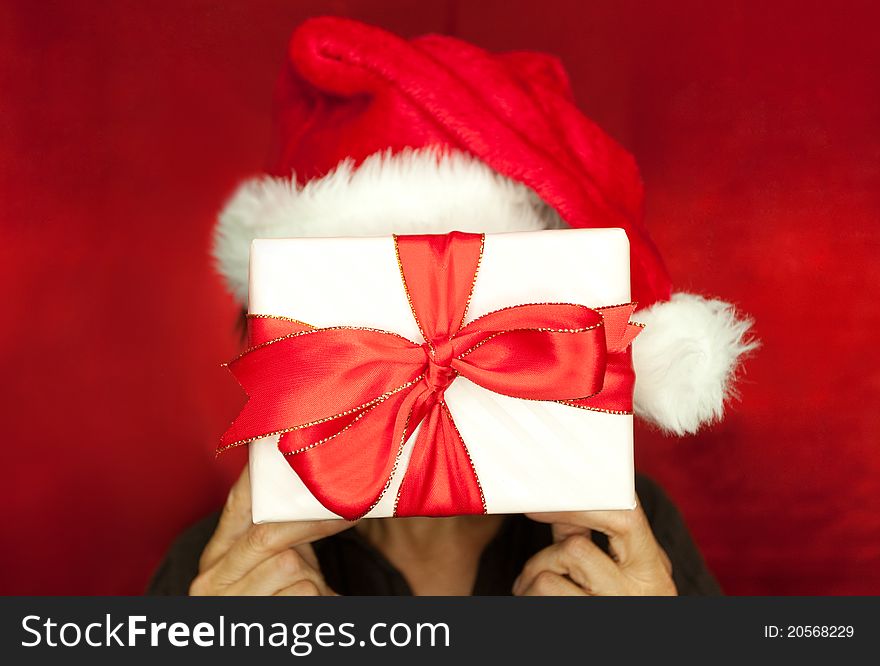 Gift in front of face isolated on red