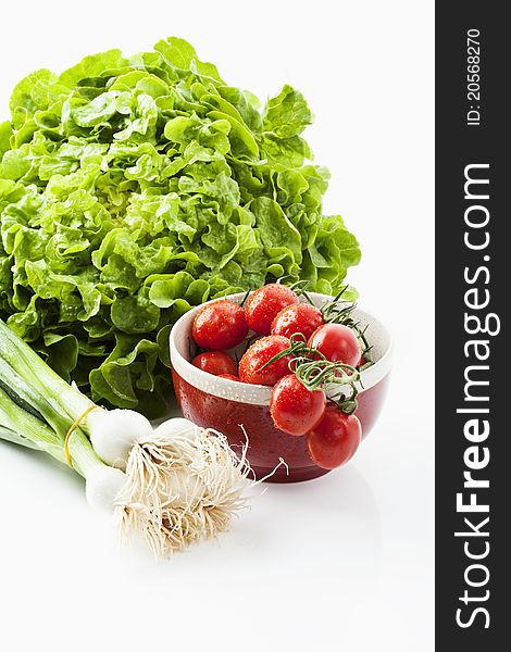 Salad, tomatoes and spring onions on white background. Salad, tomatoes and spring onions on white background