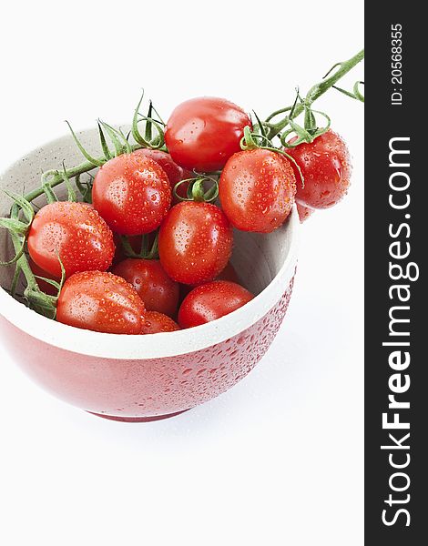 Tomatoes in a red bowl on white background. Tomatoes in a red bowl on white background