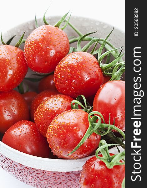 Tomatoes in a red bowl on white background. Tomatoes in a red bowl on white background