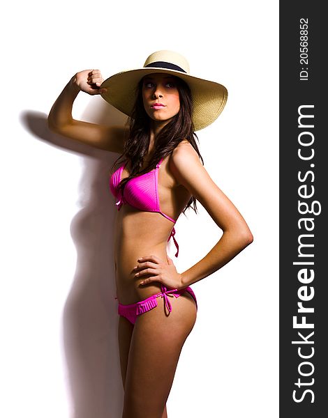 Beautiful brunette with summer hat in pink bikini. Beautiful brunette with summer hat in pink bikini