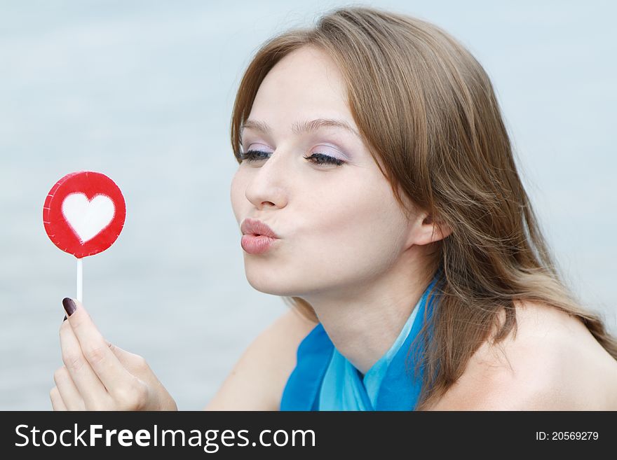 Young beautiful woman eating candy lollipops on white background.