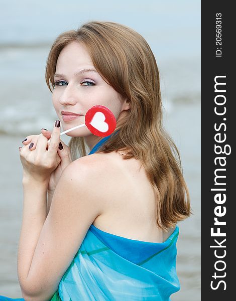 Young beautiful woman eating candy lollipops on white background.