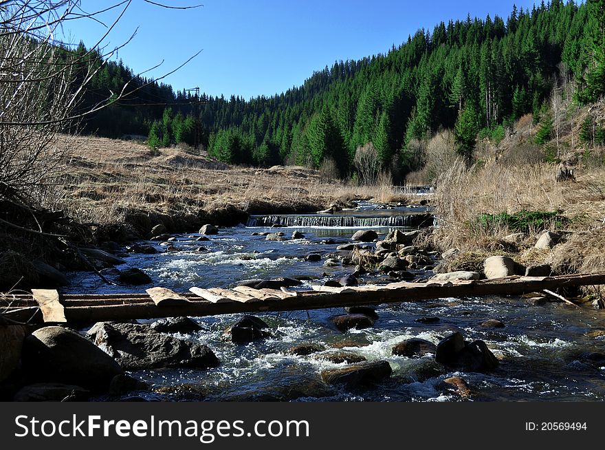 A mountain river with stream falling into it.