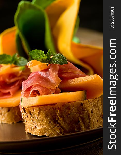 Photo of tasty bread slices with bacon and melon. Photo of tasty bread slices with bacon and melon