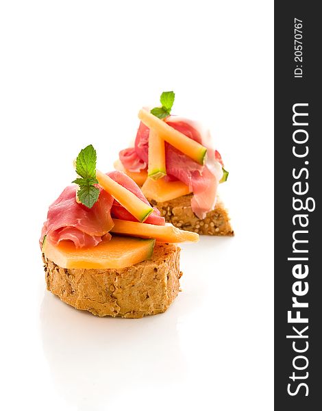 Photo of tasty bread slices with bacon and melon on isolated background. Photo of tasty bread slices with bacon and melon on isolated background
