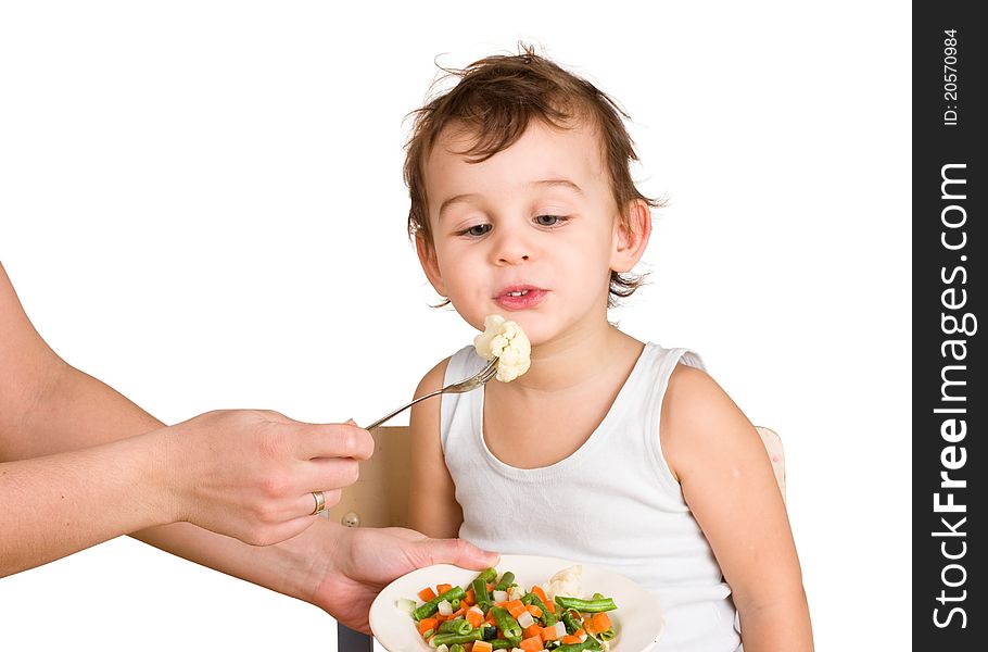 Little boy tasting vegetable salad isolated on white