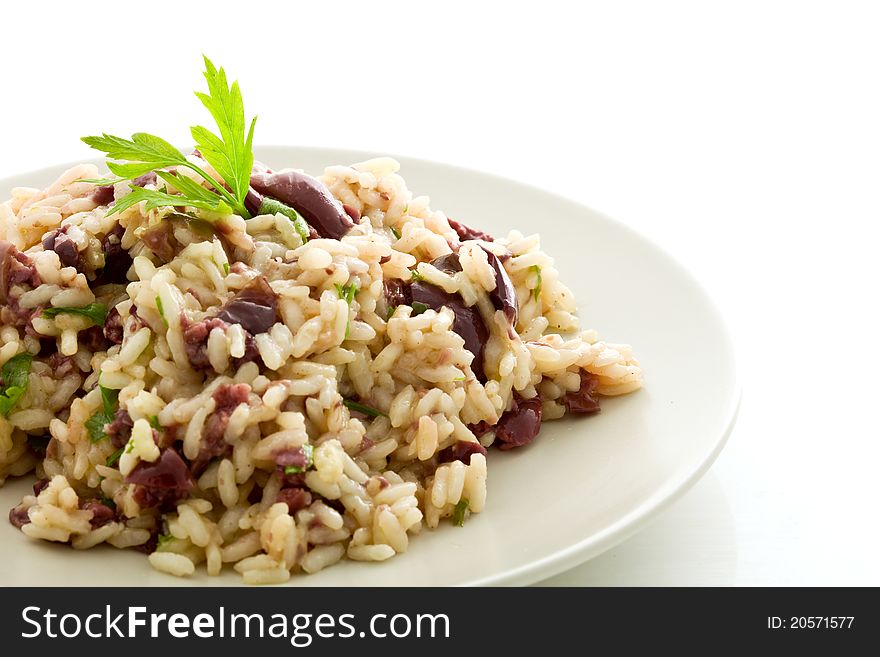 Delicious risotto with black olives on white isolated background