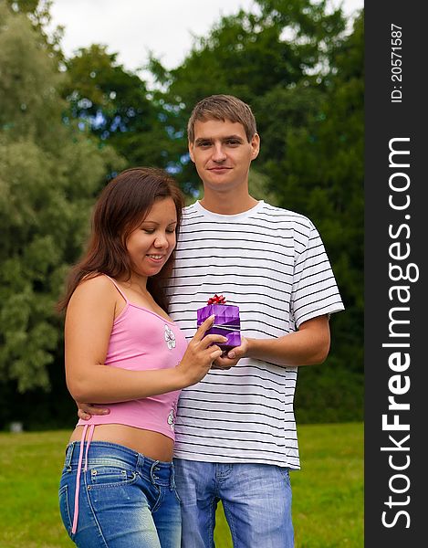 Young man giving present to his girlfriend. Young man giving present to his girlfriend