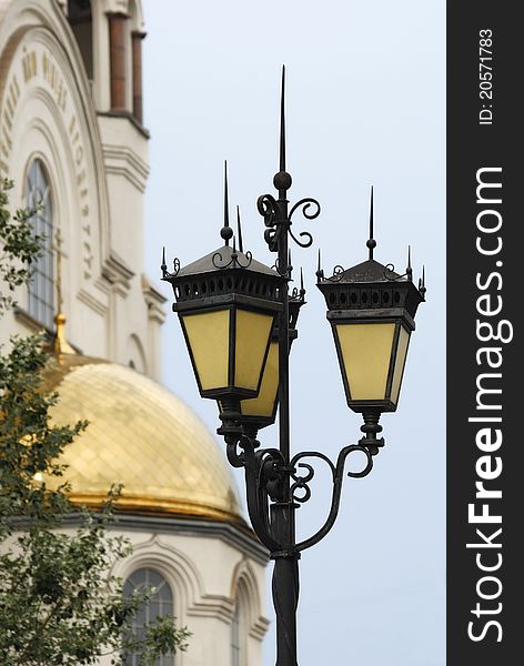 Ancient street lantern against church