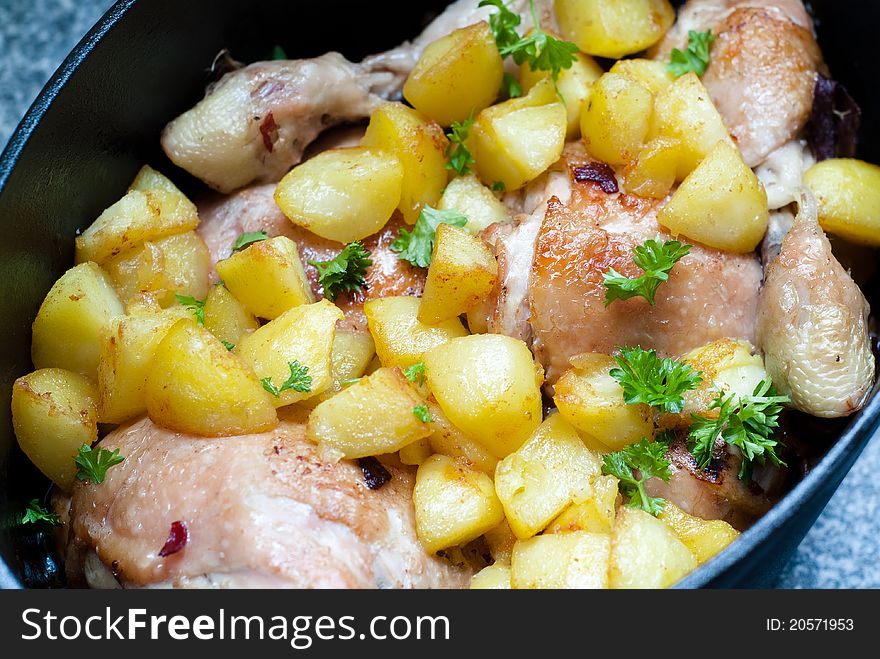 Chicken dish in cast iron pot with mushrooms, potatoes and parsley. Chicken dish in cast iron pot with mushrooms, potatoes and parsley