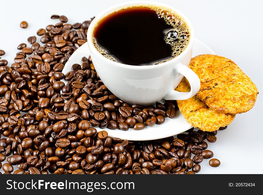 Chocolate cookies and a cup of coffee surrounded by coffee beans. Chocolate cookies and a cup of coffee surrounded by coffee beans