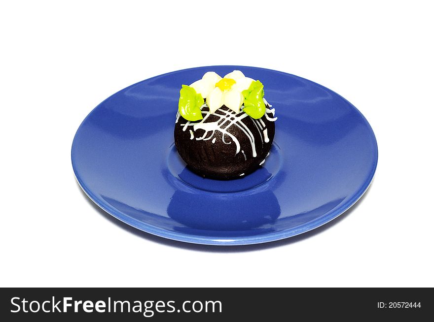 Chocolate cake with cream flower, on a blue plate. Chocolate cake with cream flower, on a blue plate