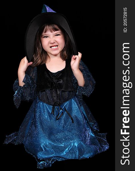 Sweet little girl dressed as a witch making a scary face. isolated. Sweet little girl dressed as a witch making a scary face. isolated