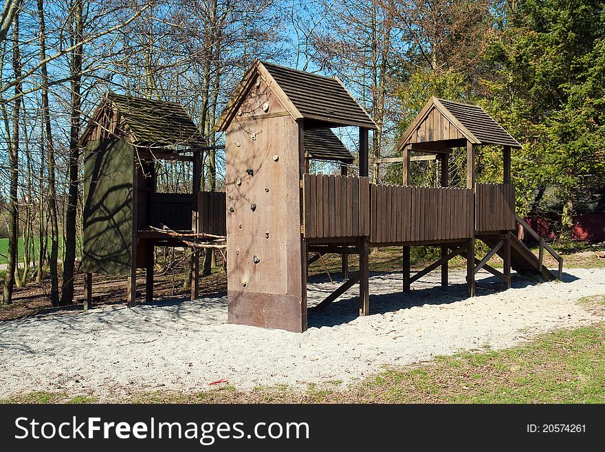 Empty wooden children playground with a slider and climbing wall in park. Empty wooden children playground with a slider and climbing wall in park