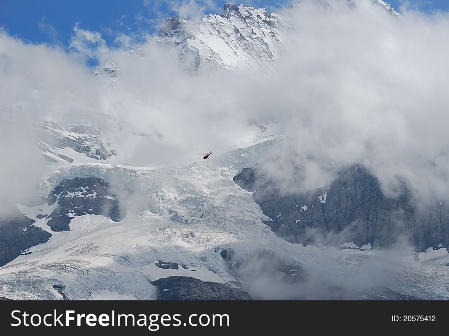 Snow mountian of Jungfraujoch in south of Swiss, a patrol helicopter within the mountain. Snow mountian of Jungfraujoch in south of Swiss, a patrol helicopter within the mountain