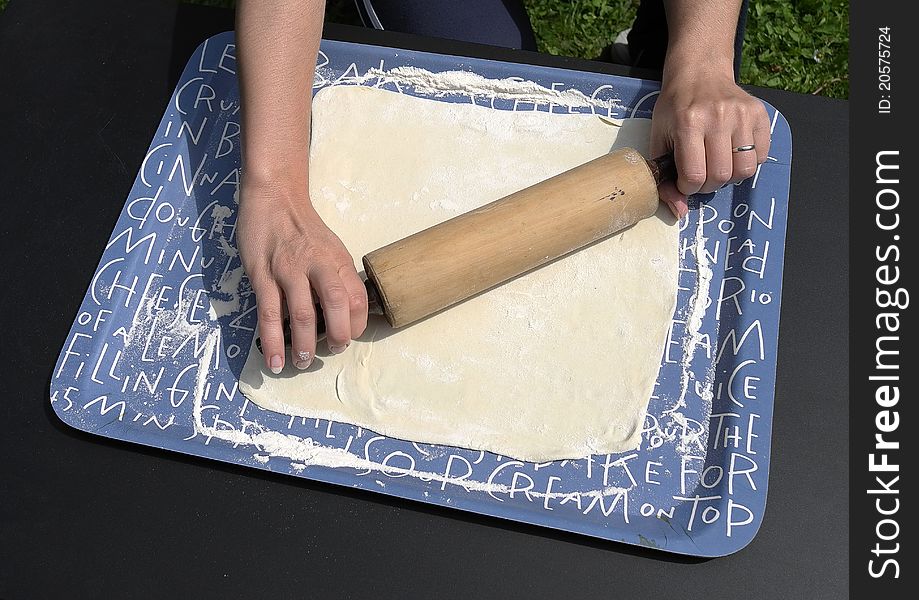 Rolling pastry dough in preparation for baking apple strudel. Rolling pastry dough in preparation for baking apple strudel.