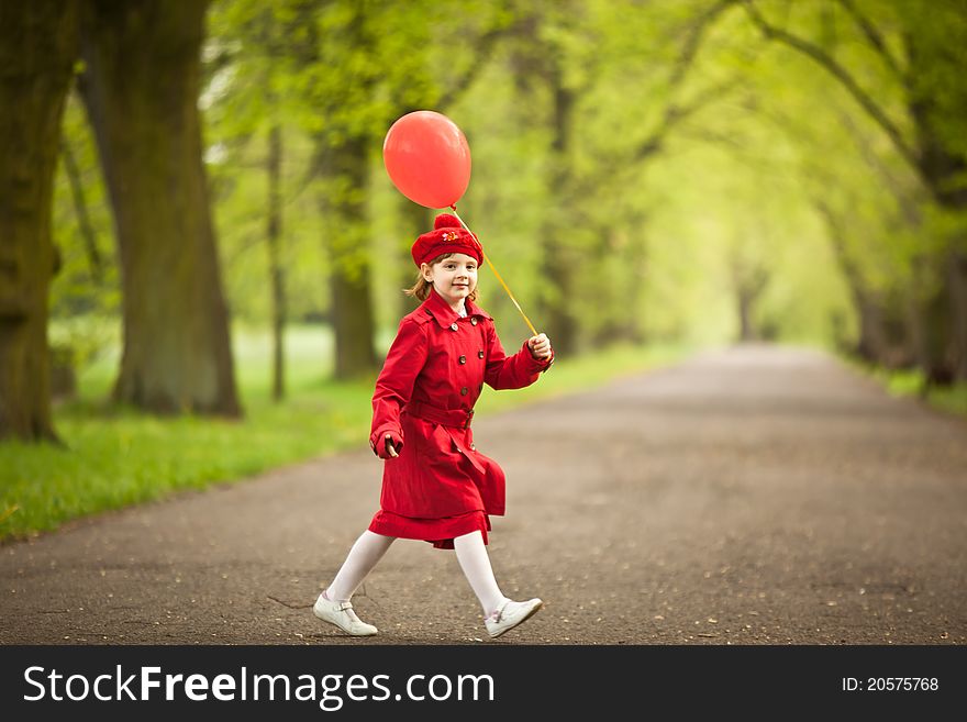 Girl wears in a red coat holding red balloon. Girl wears in a red coat holding red balloon