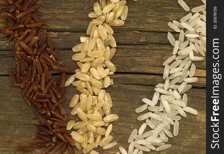 Tree types of rice over wooden background