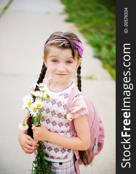 Young school girl with pink bagpack and daisies. Young school girl with pink bagpack and daisies