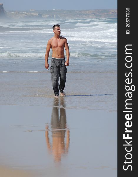 Latino man walking on a quiet beach. Latino man walking on a quiet beach