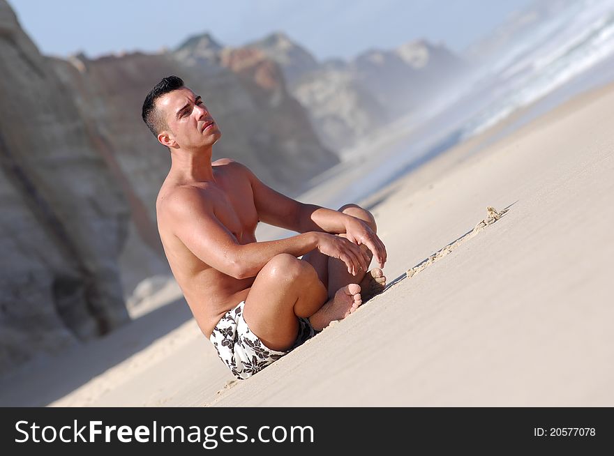 Latino man sitting on a quiet beach. Latino man sitting on a quiet beach