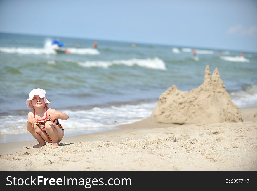 Beautiful little girl in hat relaxing at beach. Beautiful little girl in hat relaxing at beach