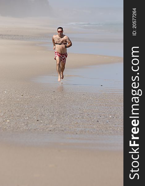 Middle age men running full of energy on the beach with a heart rate