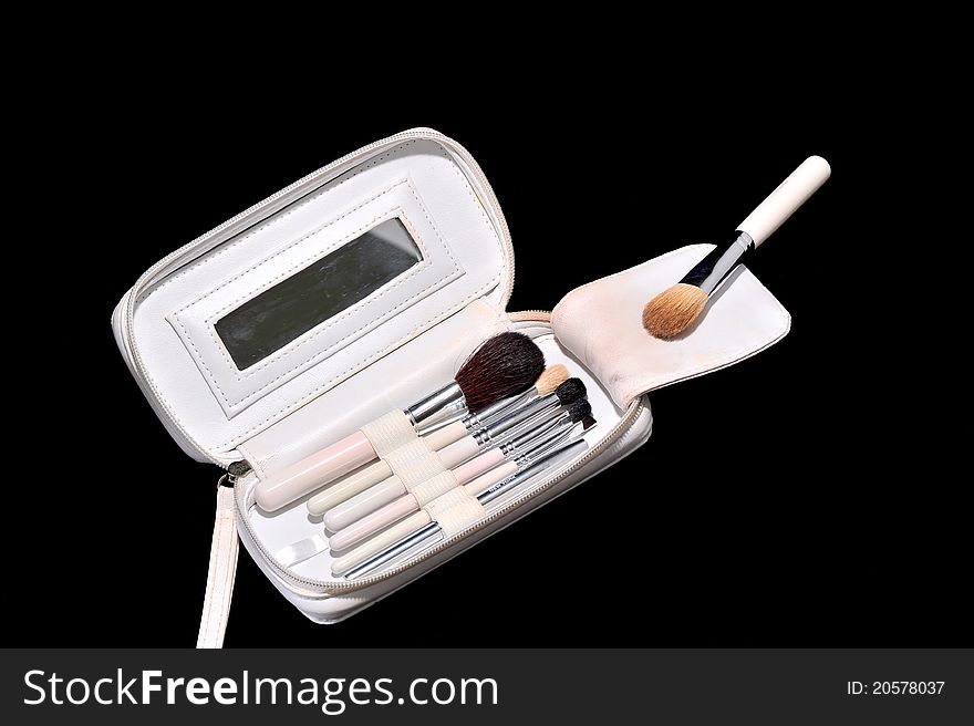 Makeup kit with brushes isolated on black copy space
