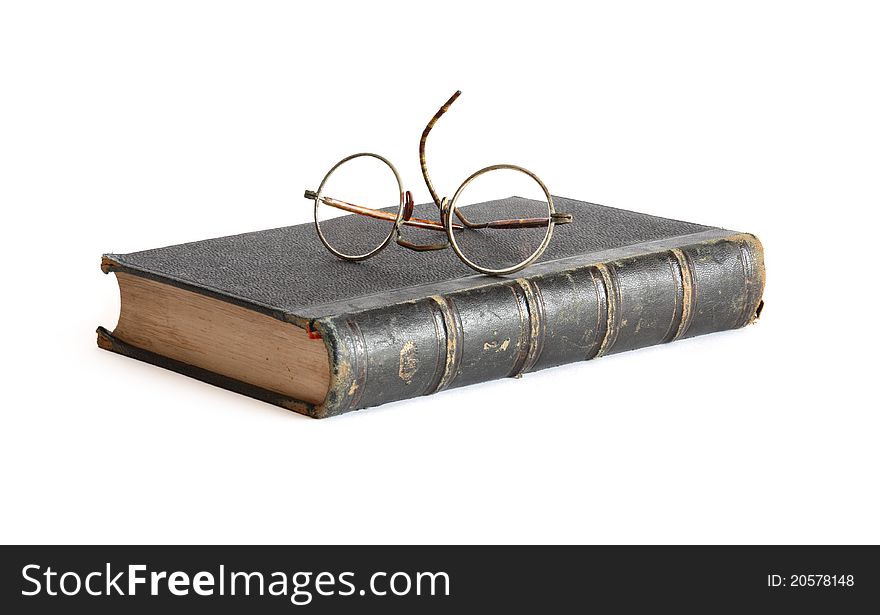 Vintage spectacles lying on old book on white background. Vintage spectacles lying on old book on white background