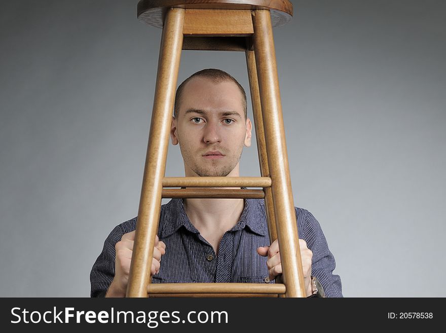 Nervous white business man posing with chair. Nervous white business man posing with chair