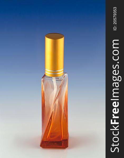 The orange perfume bottle with blue background. The orange perfume bottle with blue background.