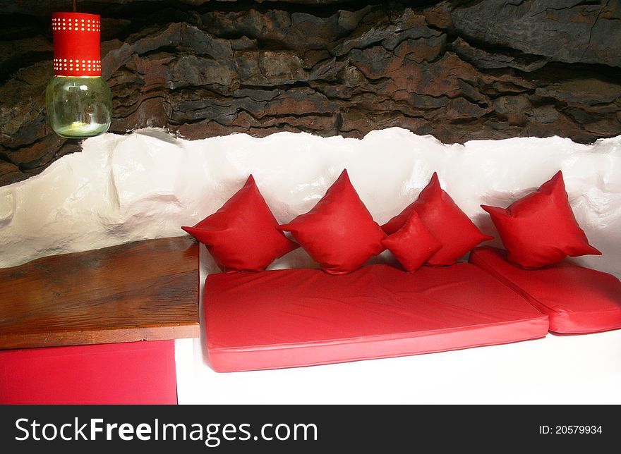 Red and white couch, black strones on the background. Red and white couch, black strones on the background.