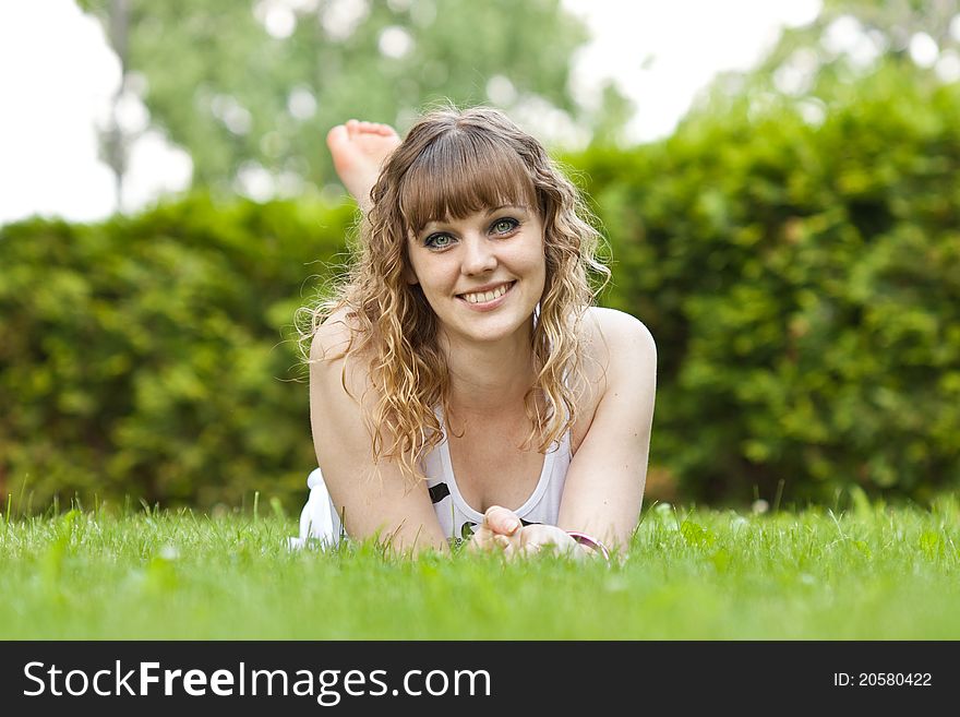 The young beautiful girl lies on a grass in park. The young beautiful girl lies on a grass in park