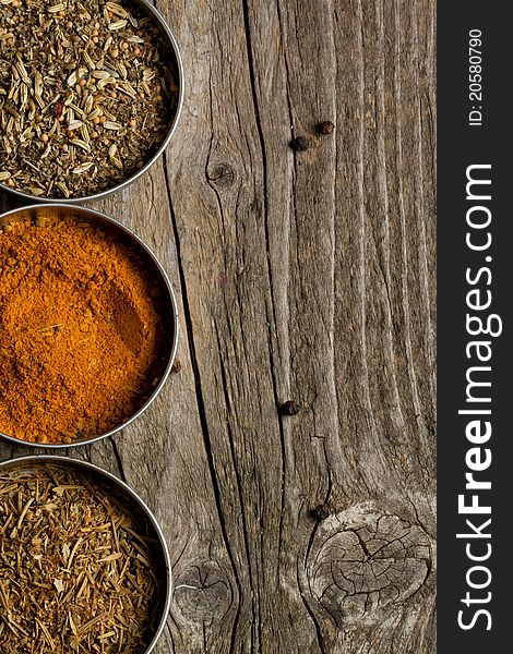 Mix of the spices on old wooden table as background