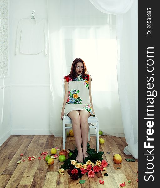 Portrait of a girl in the interior with flowers and apples