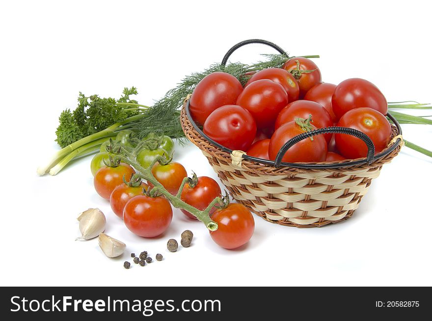 Tomatoes in basket and greens on white background. Tomatoes in basket and greens on white background